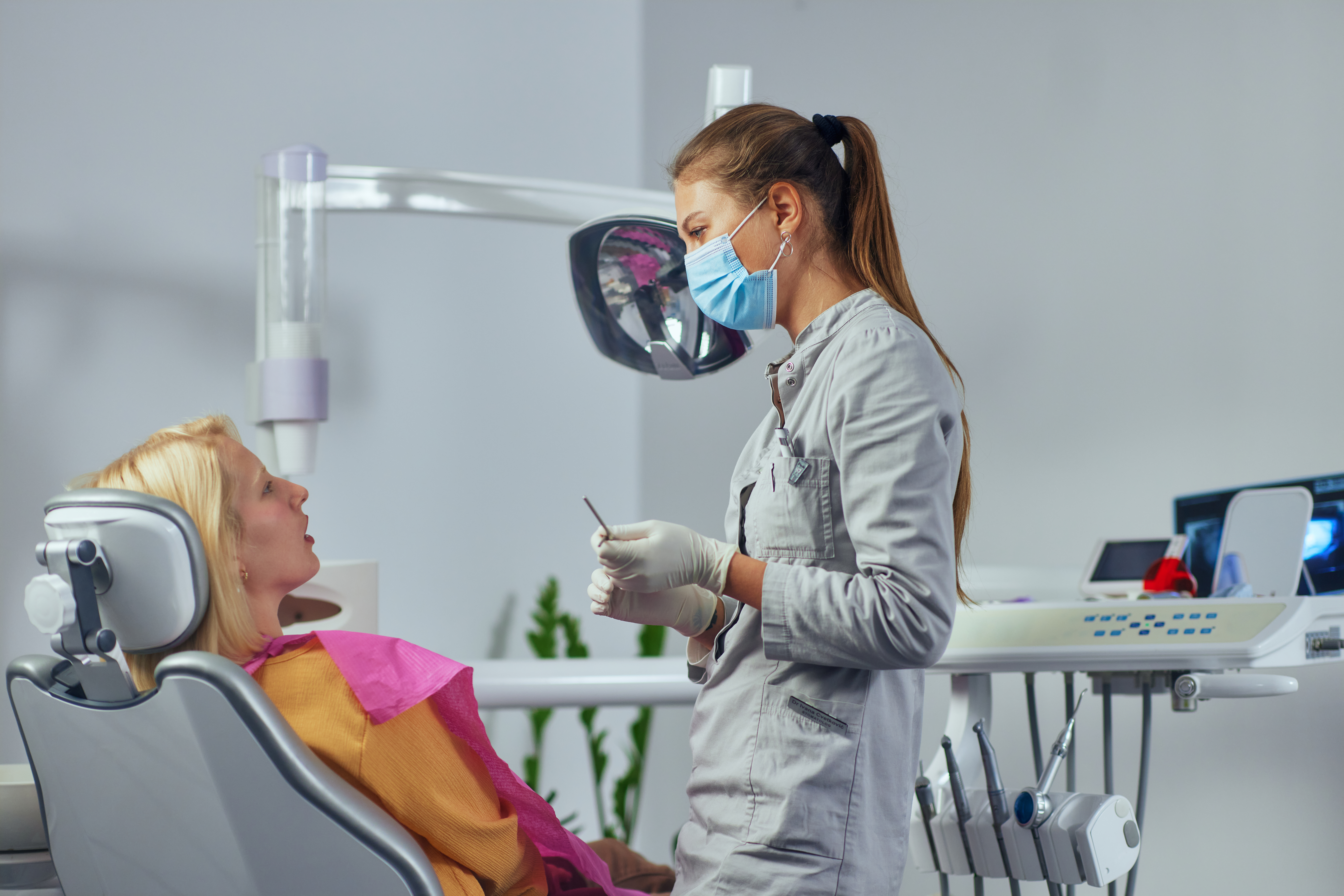 Eine Patientin unterhält sich in dem Behandlungszimmer mit der Zahnärztin